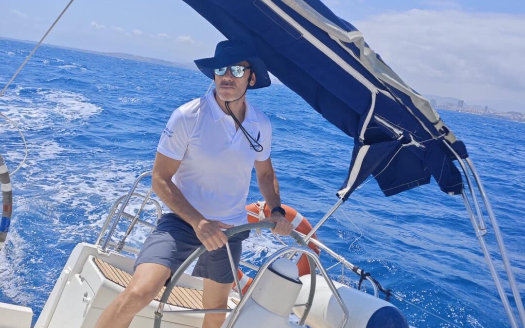Alumno al timón durante una práctica de navegación a vela en Alicante