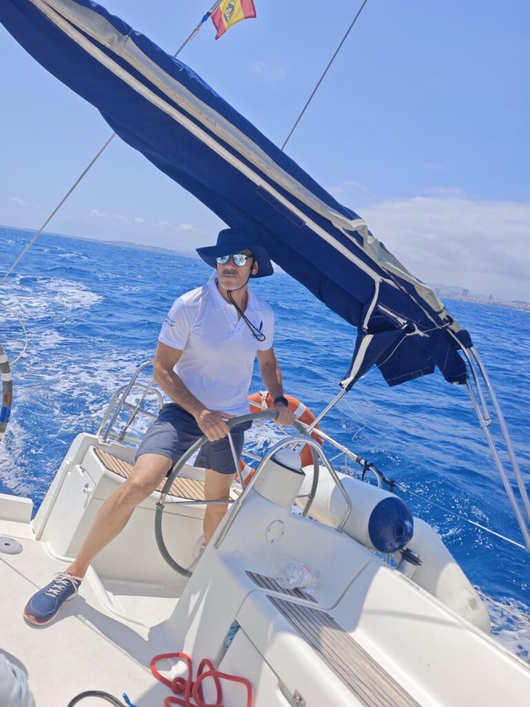 Alumno al timón durante una práctica de navegación a vela en Alicante